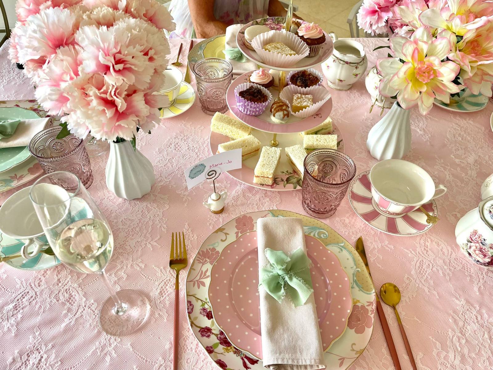 Pastel place settings with pink bows and gold cutlery