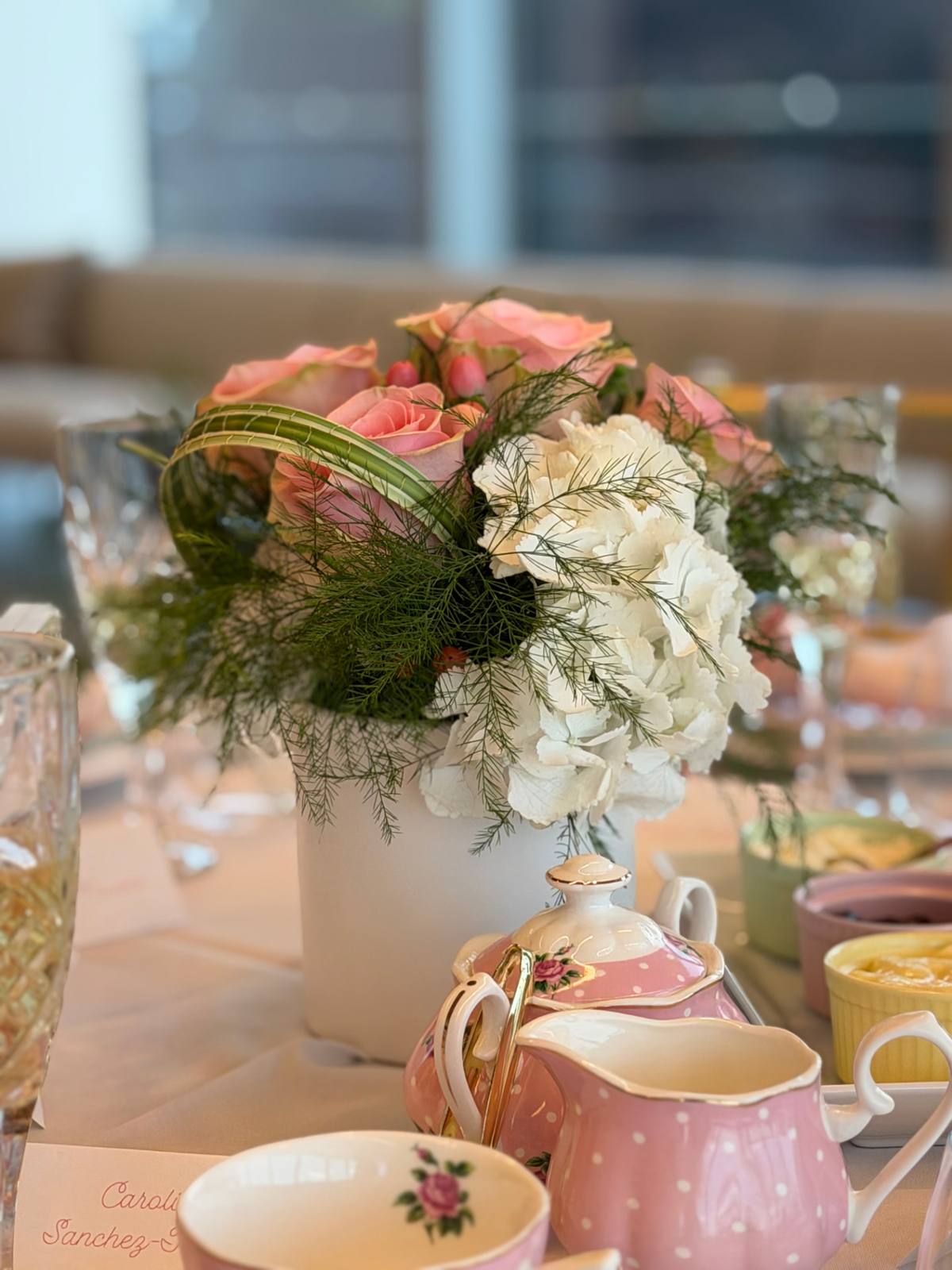 A cream and peach floral centrepiece on a styled tea table