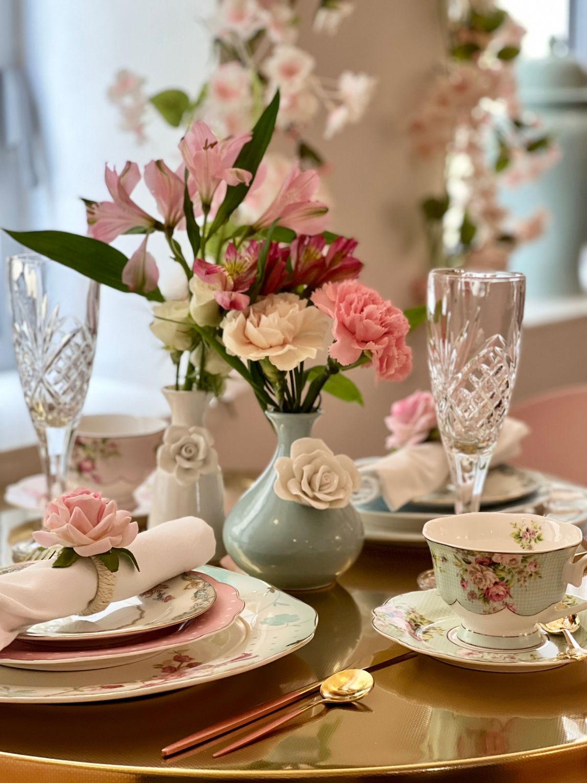 A fresh rose napkin ring detail on a styled tea table