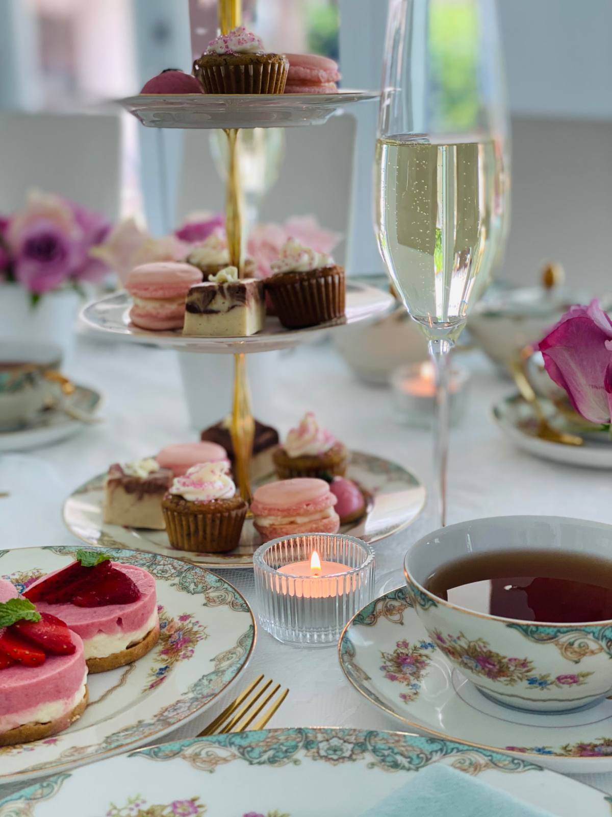 Cupcakes, macarons and candlelight on a tiered stand