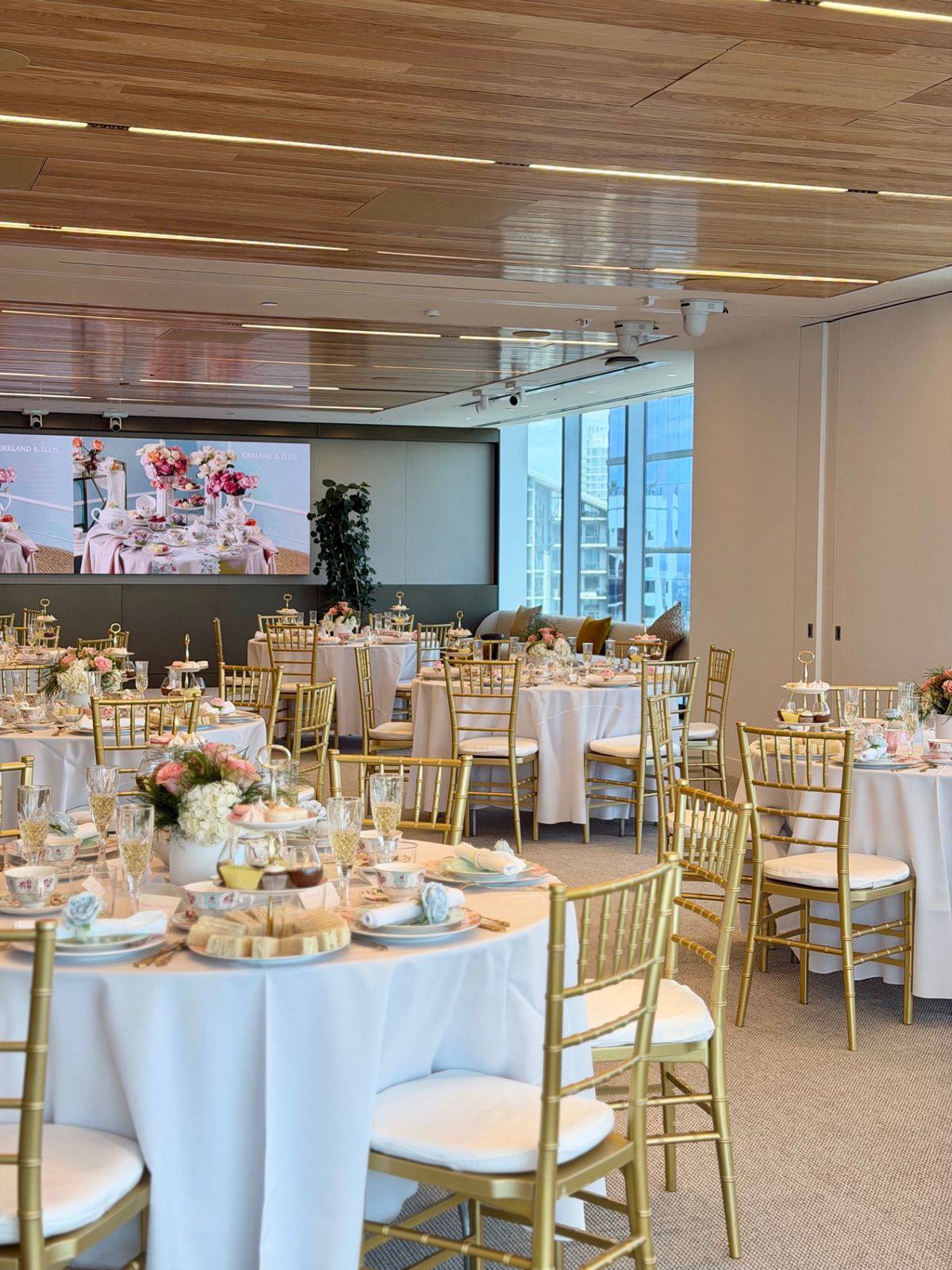 A large corporate event space in Miami set with gold chiavari chairs for an afternoon tea activation